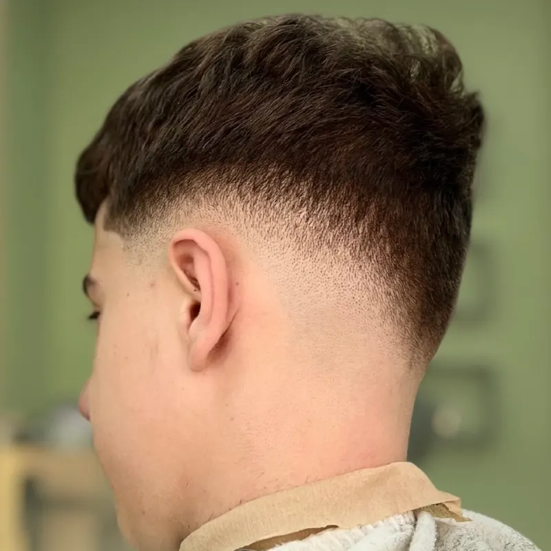 A fresh low fade, seen from behind, at Mustaqe
